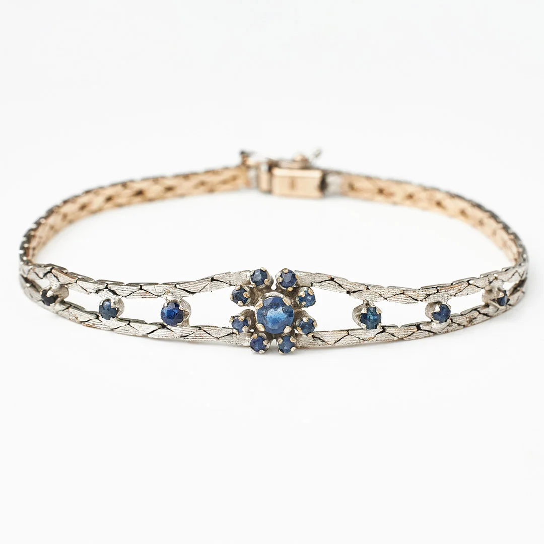 ARMBAND, låghaltigt rodierat vitguld, mittparti med dekor av 15 fasettslipade safirer. — Bracelets — Stockholms Auktionsverk Magasin 5