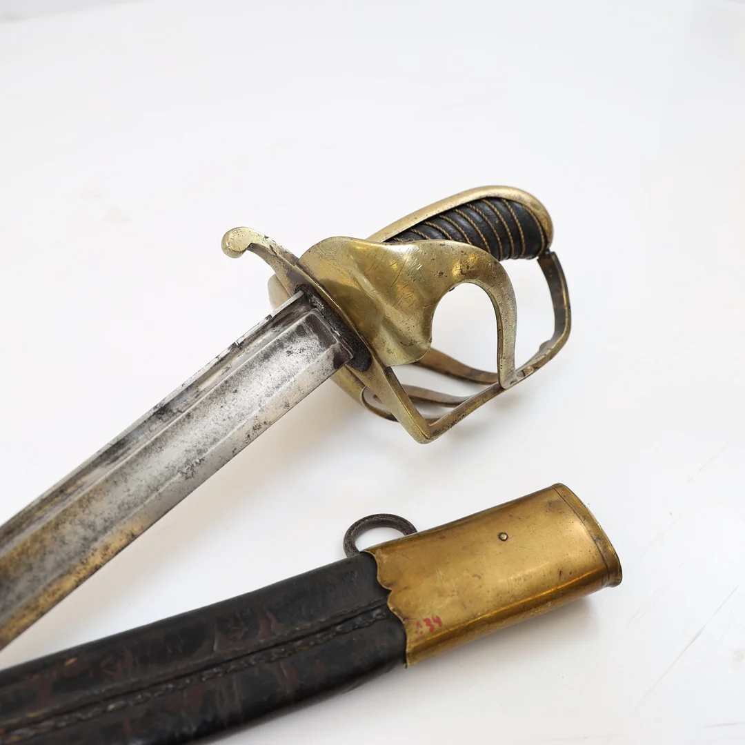 SABEL, svensk, m/1770, för manskap vid dragonregemente. Parerskydd i mässing, klinga av läder, Parerskydd med stämplade tre kronor. — Edged weapons — Falun Auktionsbyrå