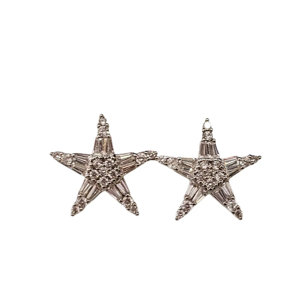 Pendientes en metal con circonitas con forma de estrella. — Earrings — Arce Auctions