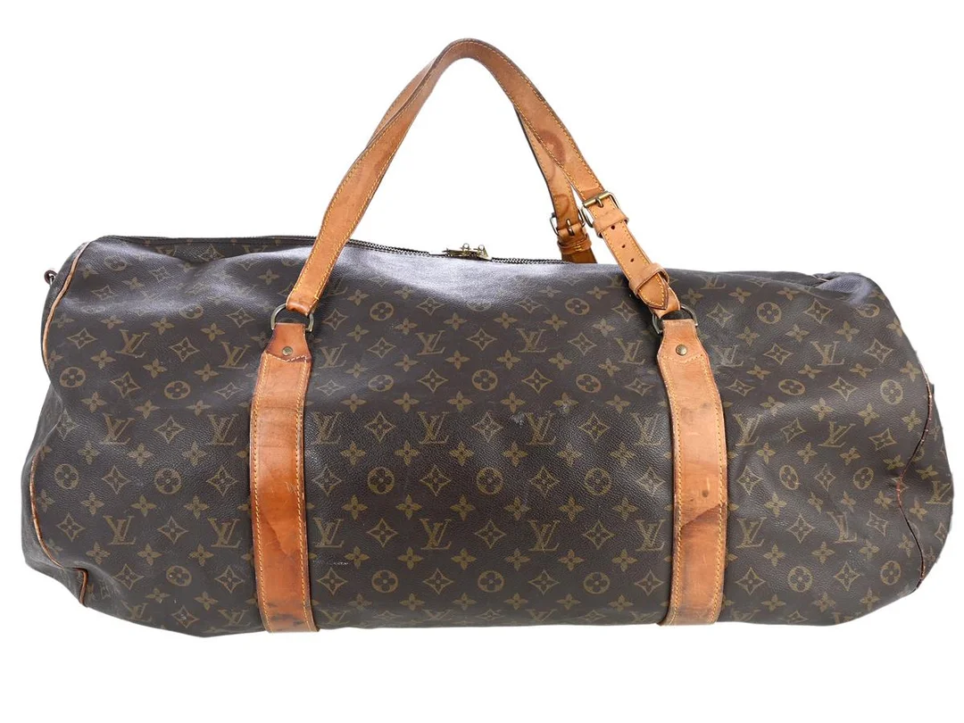 VÄSKA, LOUS VUITTON, Keepall 70, monogram canvas, guldfärgade beslag, 70x34x45 cm, slitage på läder, slitage på canvas, slitage på handtag, fläckar på foder. — Accessoarer/Väskor — Kaplans