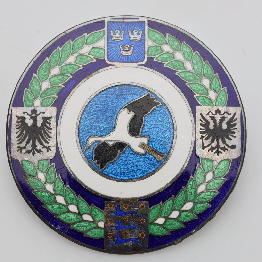 BROSCH emaljerad metall, Baltiska utställningen. — Brooches & Pendants — Höörs Auktionshall