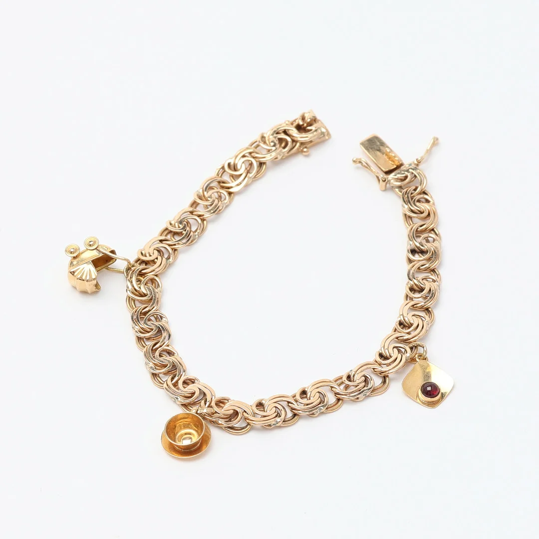 ARMBAND, guld, 18K med berlocker i form av bla. tekopp. — Bracelets — Uppsala Auktionskammare
