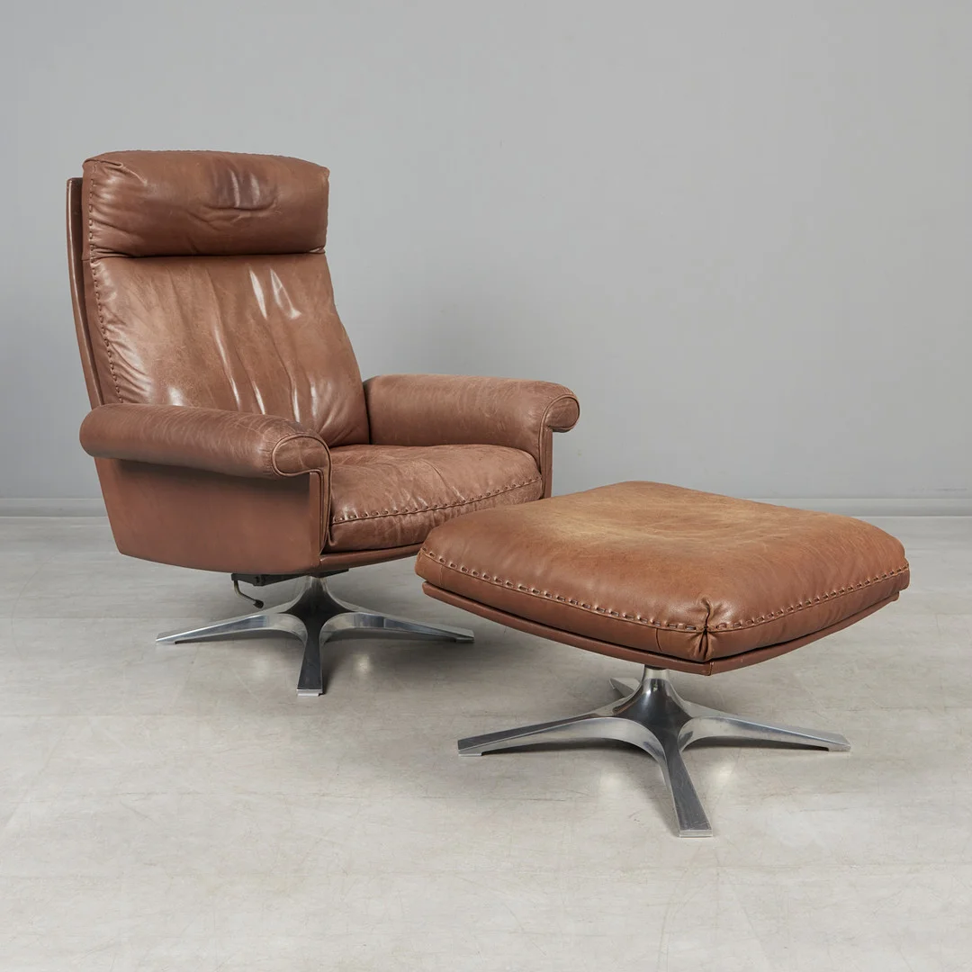 DE SEDE. Kippbarer Hochlehner / Lounge Chair mit Ottomane, Modell 'DS31', Leder, Aluminium, 1970er Jahre, Schweiz. (2). — Armchairs & Chairs — Stockholms Auktionsverk Köln