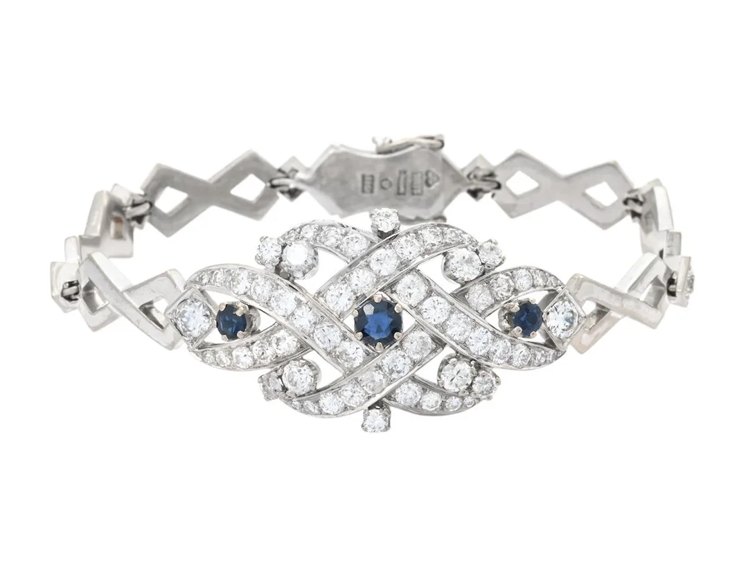 ARMBAND, 18K vitguld, 3 blå safirer, 63 briljant-, gammal- och åttkantslipade diamanter ca 4,40 ctv, ca TW-Cr/VS-P, Lawepe Guldsmedsateljé Georg Perenyi, Stockholm 1958, längd 17,5 cm, vikt 33,9 g, enstaka diamanter skadade. — Smycken/Armband — Kaplans