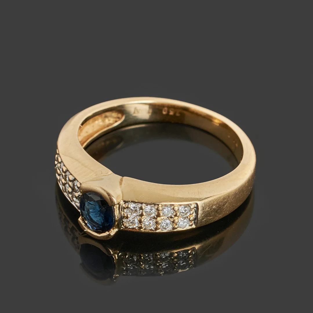 RING, 18k guld dekorerat med en mörkblå safir samt 16 st biljanter totalt ca 0.15ct. — Rings — Crafoord Auktioner Stockholm