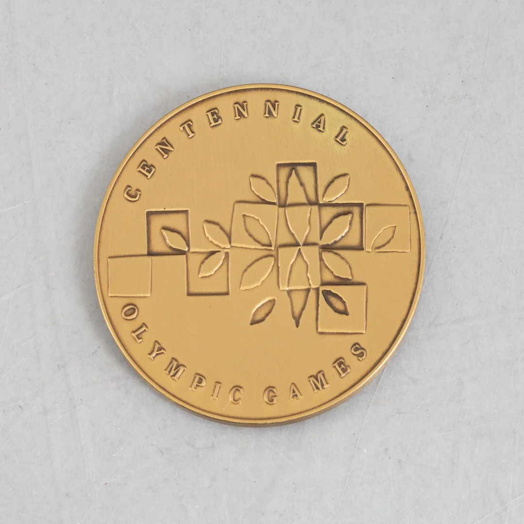 Deltagarmedalj OS, Atlanta 1996 samt tygmärke för den svenska OS-truppen. — Samlarföremål/Övrigt — Bukowskis