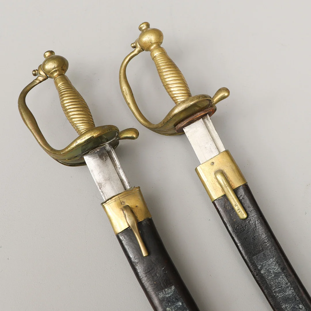 HUGGARE, 2 st., svenska, m/1748-1856, svarta läderbaljor med mässingsbeslag. — Edged weapons — Crafoord Auktioner Malmö