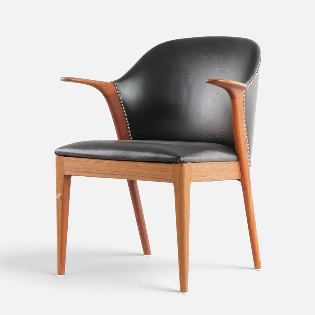 KNUD A. RISAGER HANSEN. Armstol med stel af massiv teak, betrukket med sort sømbeslået kunstlæder. Udført hos Slagelse Møbelværk, model '31'. Danmark, 1950-60'erne. — Armchairs & Chairs — Woxholt Auktionshus