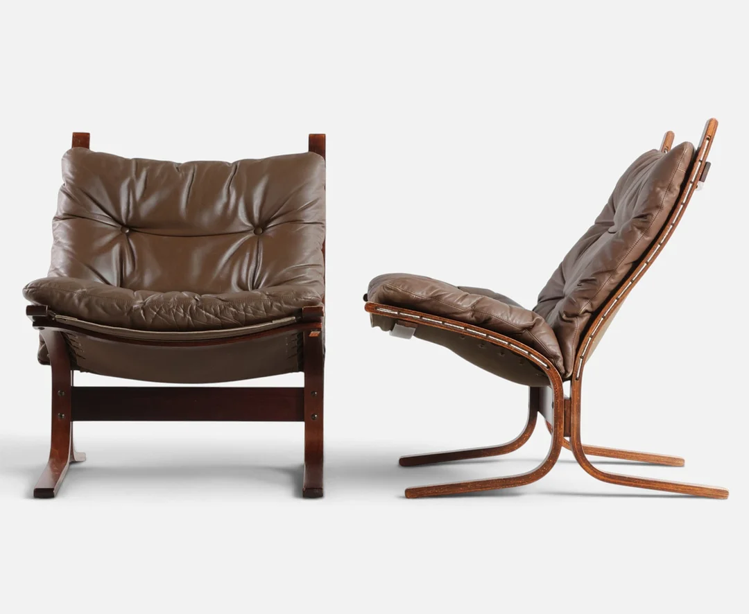 INGMAR RELLING. 'Siesta', et par lænestole med stel af mørkbejdset træ, hynder betrukket med dybthæftet skind. Udført og mærket hos Westnofa, Norge (2). — Armchairs & Chairs — Woxholt Auktionshus