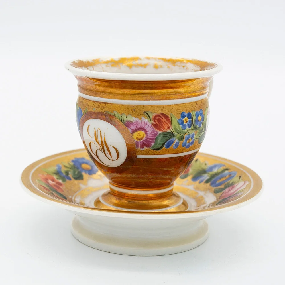 PORZELLAN TASSE MIT UNTERTELLER, ANFANG 19. JAHRHUNDERT FRANZÖSISCH EMPIRE, KARTUSCHE MIT MONOGRAMM, HANDBEMALT, MIT BLUMENDEKOR. — European — Kunst- und Auktionshaus Kleinhenz