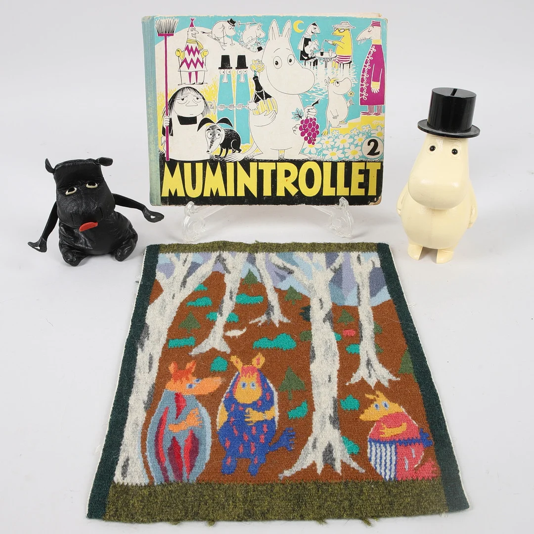 MUMINFÖREMÅL, 4 delar, bl.a. bok Mumintrollet 2 och sparbössa Muminpappa, Tove Jansson, 1900-talets andra hälft. — Other collectables — Ekenbergs Auktioner
