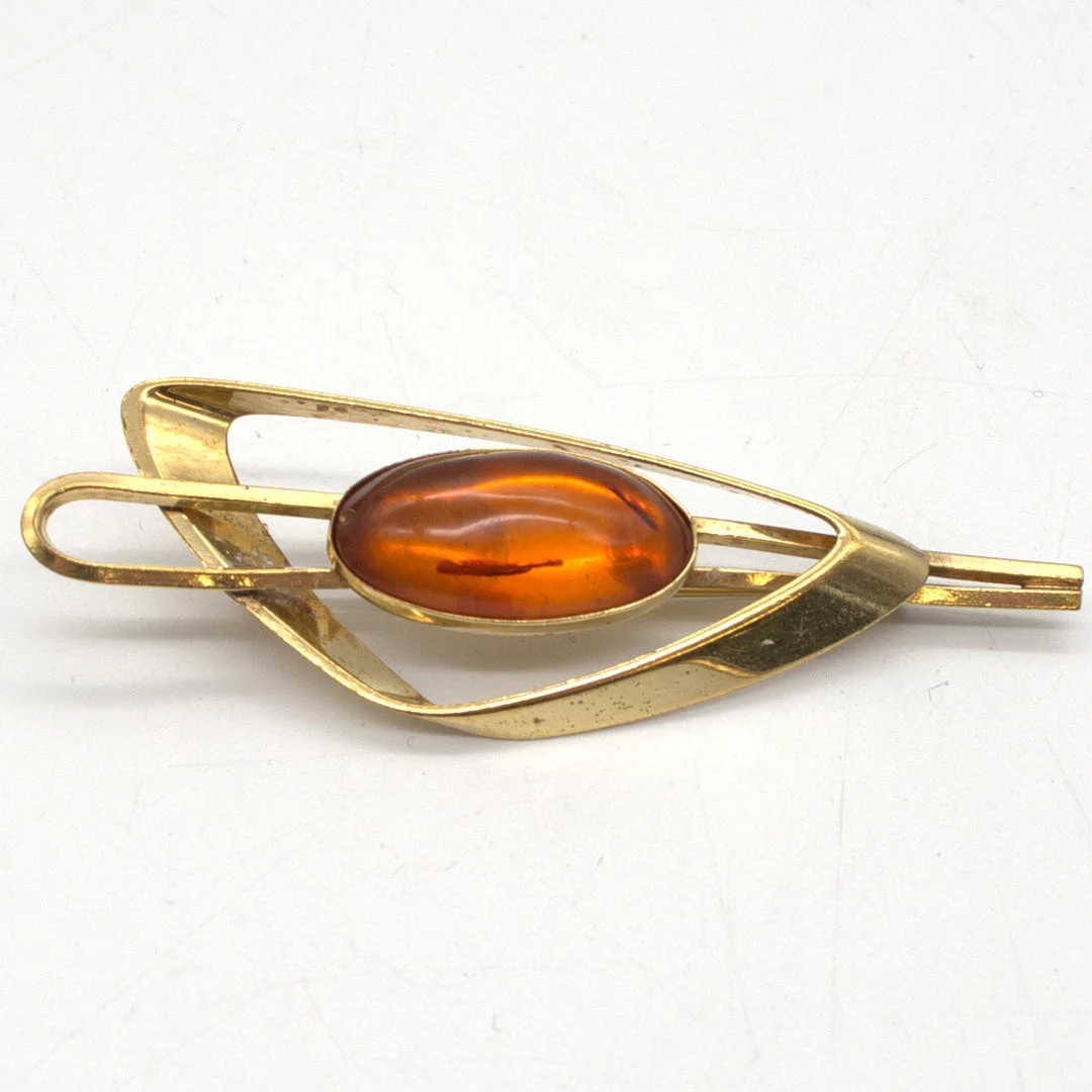 KORDES & LICHTENFELS. ,DESIGNER BROSCHE MIT BERNSTEIN, DURCHBROCHENE FASSUNG, AMERIKANER GOLD DOUBLÉ 20. JAHRHUNDERT. — Brooches & Pendants — Kunst- und Auktionshaus Kleinhenz