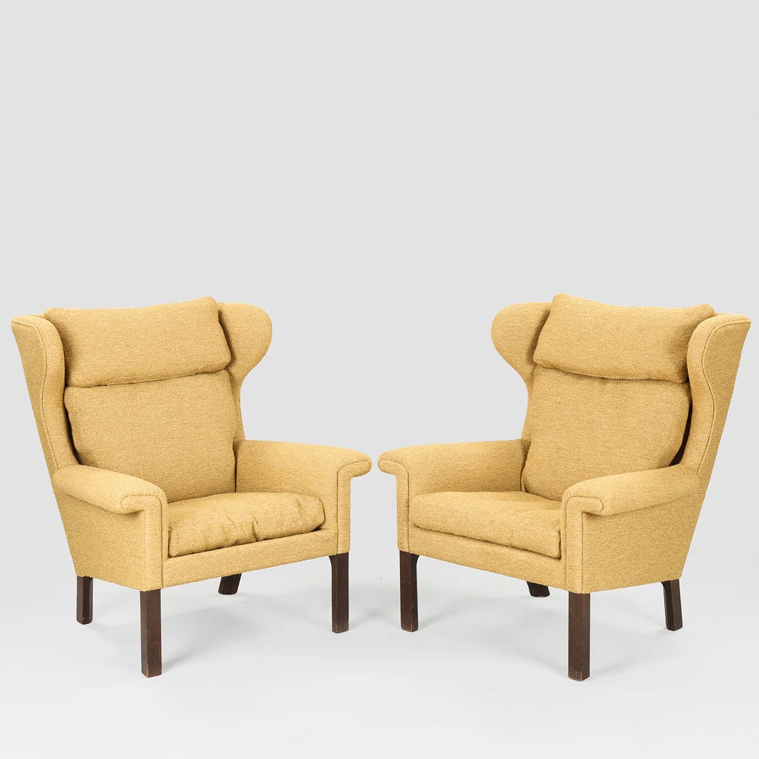 HANS J. WEGNER (1914-2007). Et par nypolstrede øreklapstole betrukket med bouclé, ben af bejdset egetræ, Johannes Hansen, Danmark, 1960'erne, (2). — Armchairs & Chairs — Palsgaard Kunstauktioner