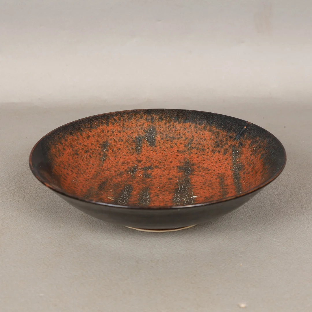 STUDIO POTTERY; SALLY REILLY (BORN 1958); A SMALL STONEWARE CIRCULAR DISH OR BOWL, TENMOKU OIL SPOT GLAZE. — European — Bishop & Miller
