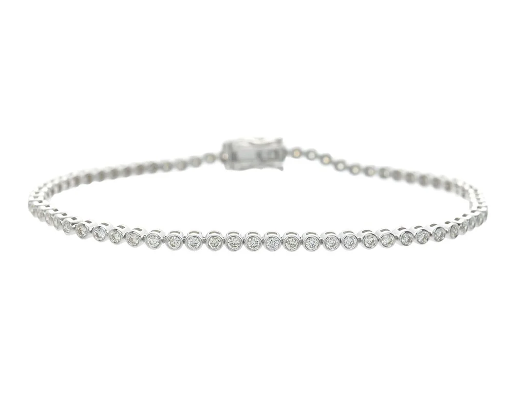 TENNISARMBAND, 18K vitguld, 69 briljantslipade diamanter ca 1,28 ctv, ca TW-Cr/VVS-VS, längd 17,5 cm, vikt 7,0 g. — Smycken/Tennisarmband — Kaplans