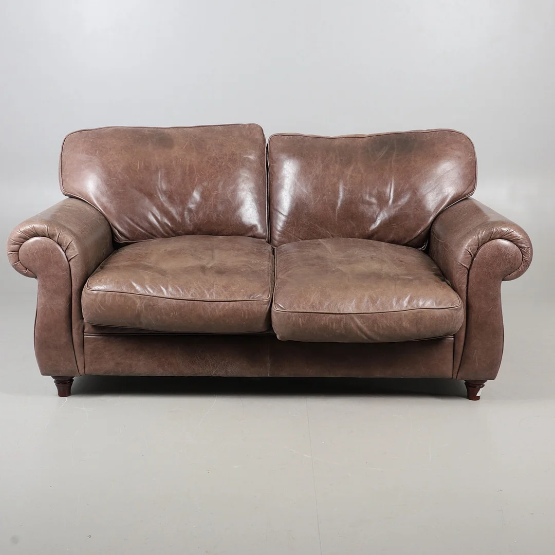 A MODERN BROWN LEATHER TWO SEATER SETTEE. — Sofas & Seatings — Lawrences Auctioneers