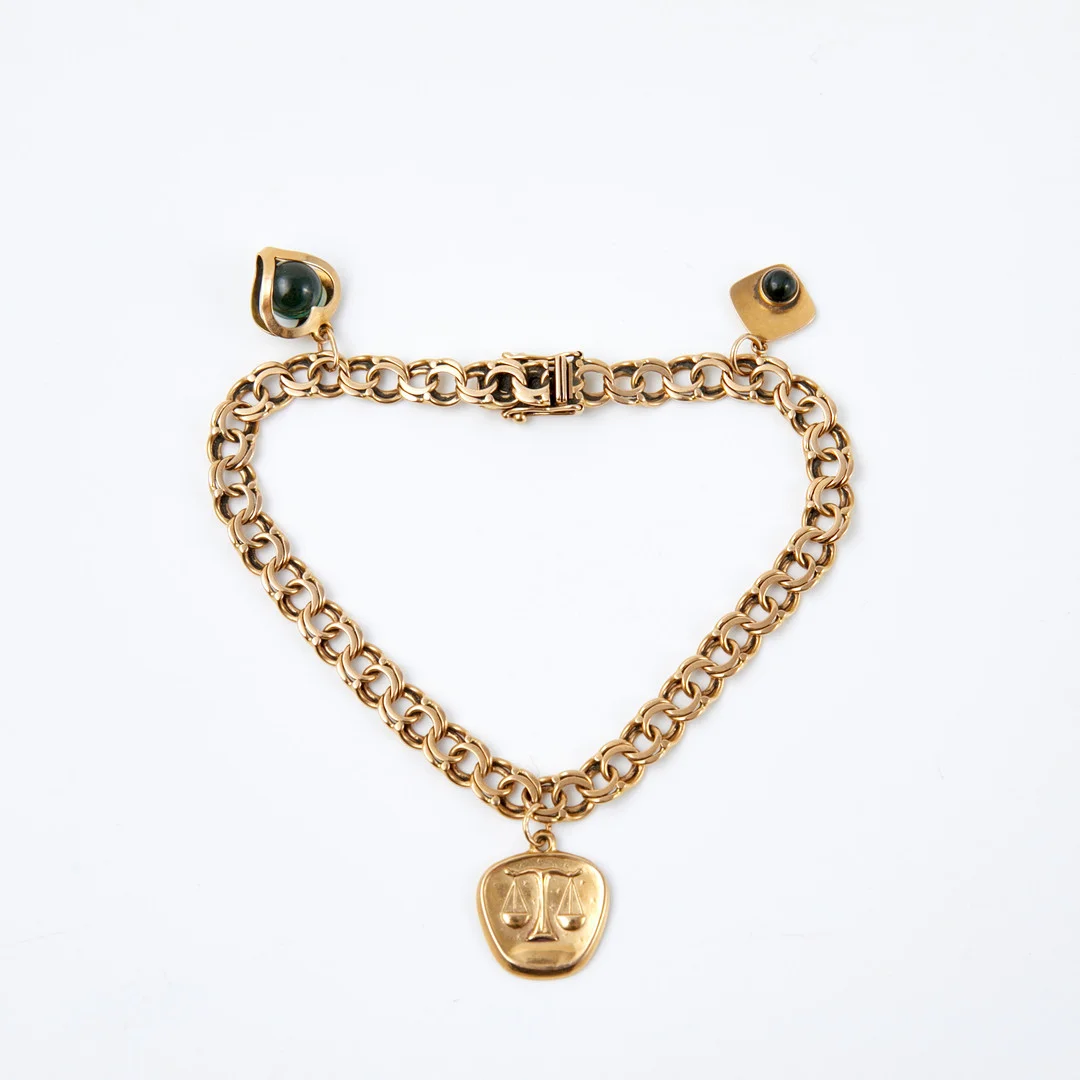ARMBAND, 18 k guld, bismarcklänk, behängd med 3 berlocker, varav 2 st med grön glasmassa. — Bracelets — Stockholms Auktionsverk Sickla