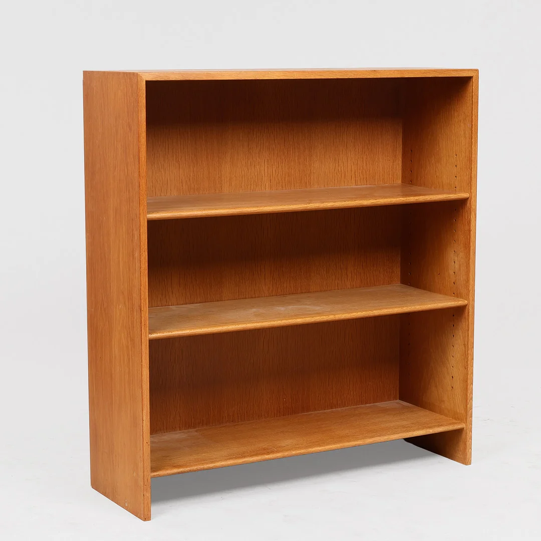 HANS J WEGNER. Bogreol af egetræ med to flytbare hylder, stemplet og udført hos Ry Møbelfabrik, Danmark, dateret 1956. — Cupboards, Cabinets & Shelves — Palsgaard Kunstauktioner