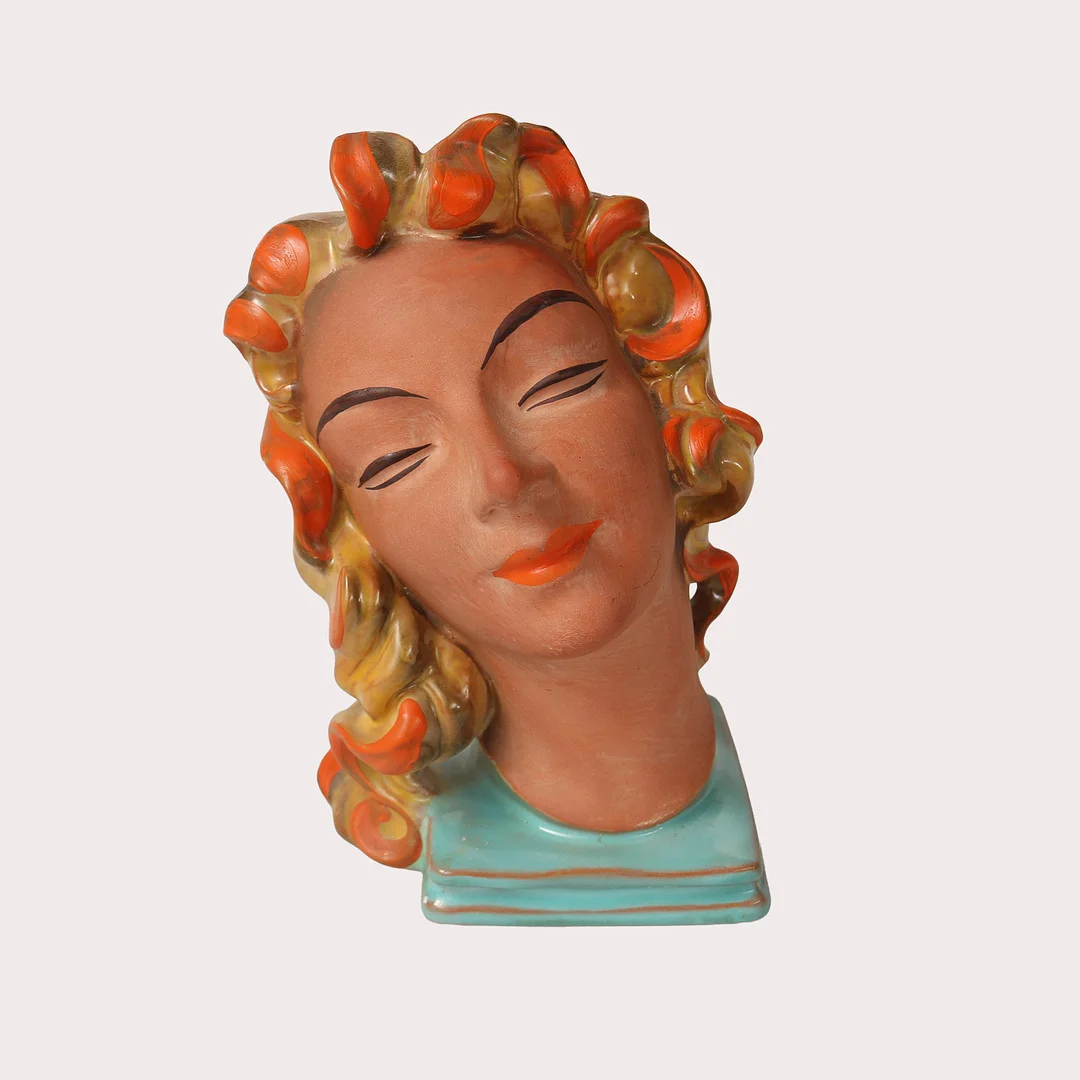 SKULPTUR i form av ett kvinnoansikte på sockel, delvis glaserad keramik, art deco, 1930- tal, märkt 14259. — European — Limhamns Auktionsbyrå