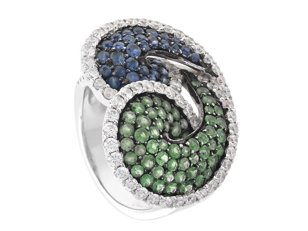 RING, 18K vitguld, delvis svartrodinerat, safirer, tsavoriter, briljantslipade diamanter ca 1,30 ctv, stl 17,25 mm, vikt 13,6 g. — Smycken/Ring — Kaplans