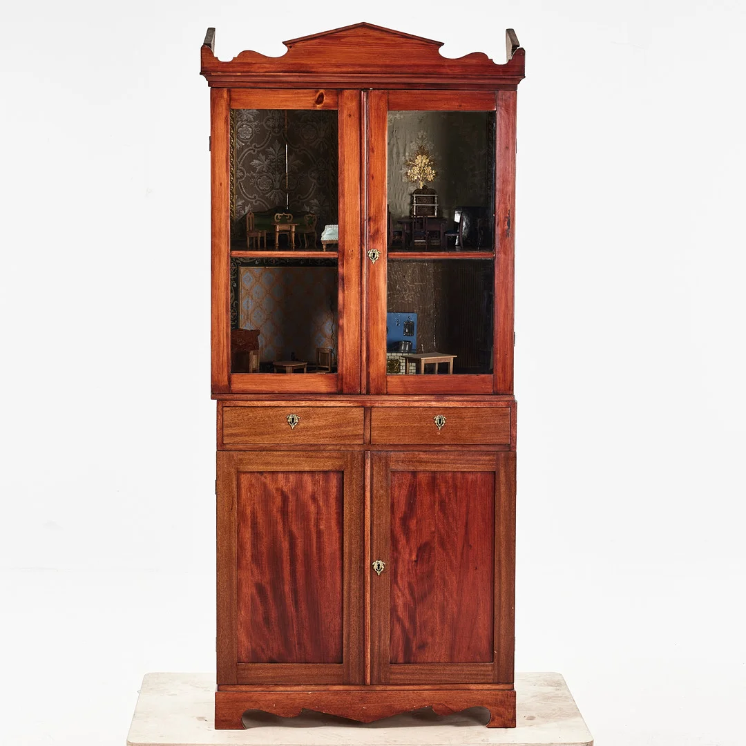 DOCKSKÅP, omkring 1900, delvist fanerat i mahogny/betsad furu, två delar, överdel med glasade dörrar, invändigt tapetserad samt möblerat. — Other toys — Stockholms Auktionsverk Magasin 5