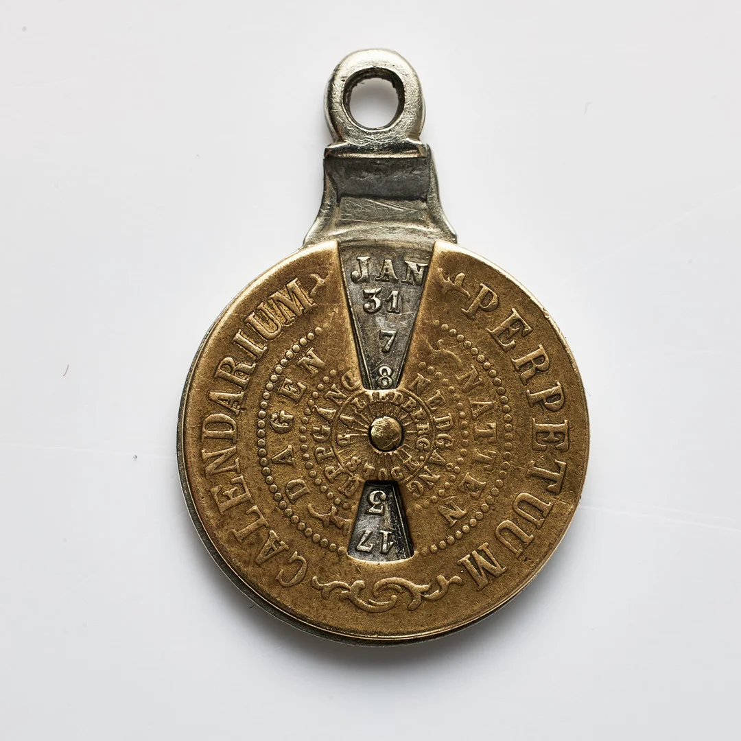 EVIGHETSKALENDER, "Calendarium Perpetuum", i form av mynt, vitmetall & mässing, sannolikt 1800-tal. — Other — Stockholms Auktionsverk Magasin 5