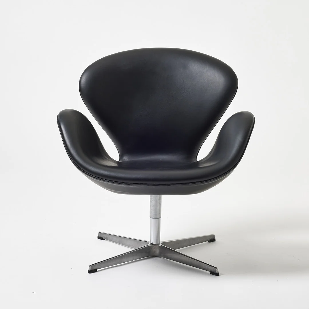 ARNE JACOBSEN. "Svanen", Fritz Hansen, Danmark, modellen formgiven kring 1957, aluminium med klädsel i svart läder. — Armchairs & Chairs — Stockholms Auktionsverk Magasin 5