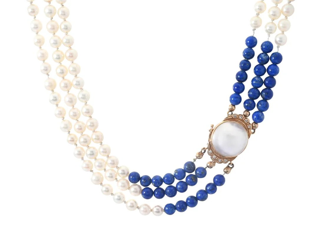 PÄRLCOLLIER, 3 - radigt, odlade pärlor ca 5,25 mm, lapis lazuli, lås i 18K guld med mabépärla och åttkantslipade diamanter, distanser i gulmetall, längd 40 cm, vikt 43,3 g. I behov av omträdning. — Smycken/Pärlcollier — Kaplans