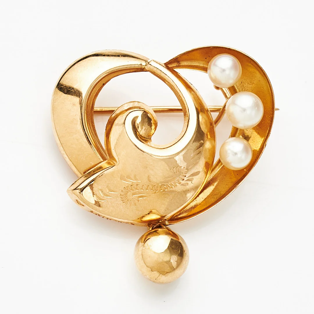 BROSCH, 18 k guld, kulformad dekordel, 3 odlade saltvattenspärlor ca 3,2 mm, svisselerad dekor, Guldvaruhuset, Stockholm 1955. — Brooches & Pendants — Stockholms Auktionsverk Magasin 5