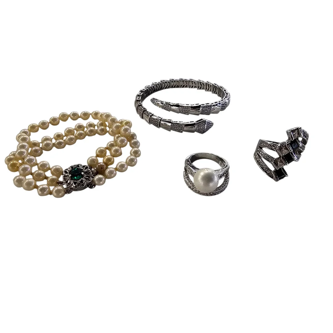 Juego de dos sortijas y dos pulseras en metal y cristal con símil perla. — Costume Jewellery — Arce Auctions