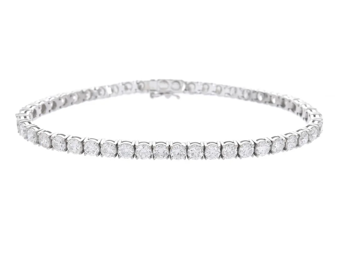 TENNISARMBAND, 18K vitguld, briljantslipade diamanter ca 8,22 ctv, ca TW-W/SI-P, längd 18 cm, vikt 14,0 g, enstaka diamanter med nagg på kuletten. — Smycken/Tennisarmband — Kaplans