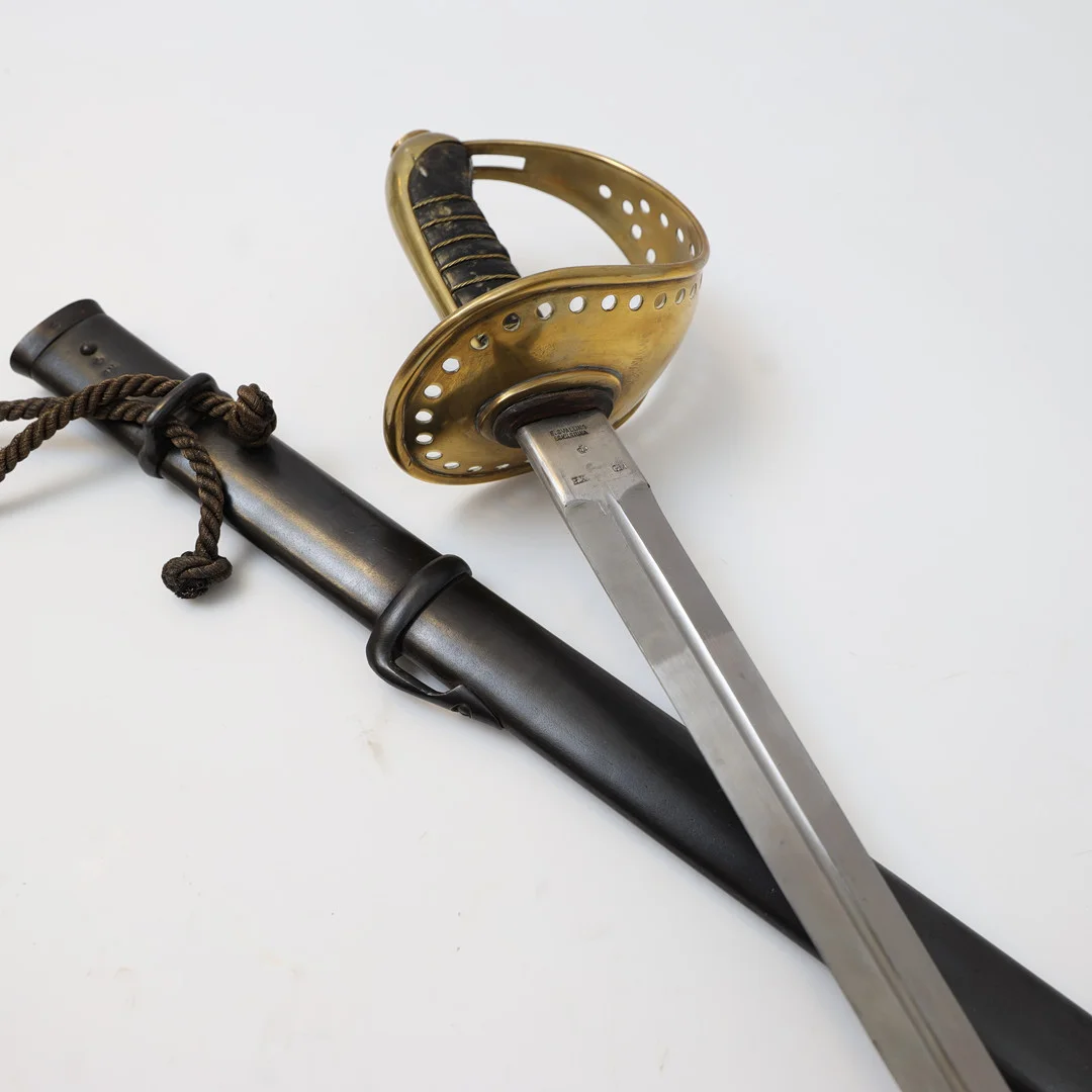 SABEL, svensk, m/1893 för kavallerimanskap, med stålbalja. Lindat trähandtag och parerskydd av mässing med delvis genombruten dekor, Stämplad. — Edged weapons — Falun Auktionsbyrå