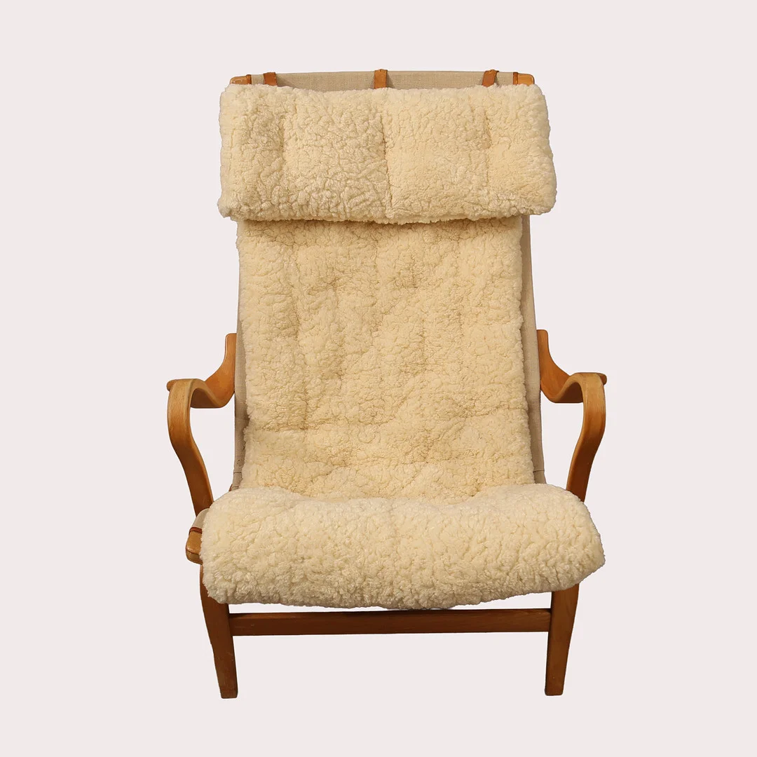 BRUNO MATHSSON. Fåtölj "Pernilla", DUX, stomme i bok med ljus fluffig klädsel och nackkudde, 1900- talets andra hälft. — Armchairs & Chairs — Limhamns Auktionsbyrå