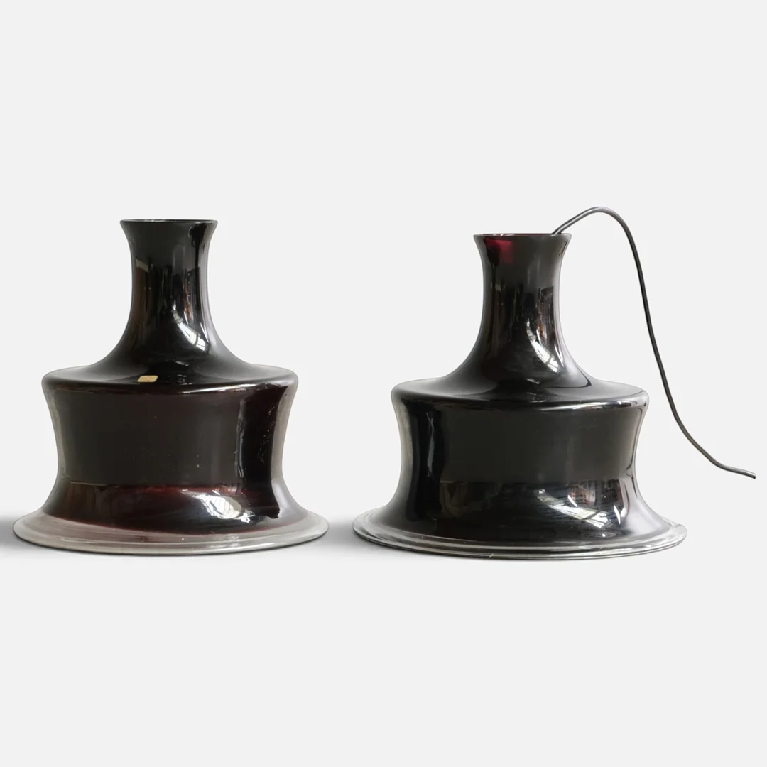 MICHAEL BANG (1942-2013). Et par pendler af aubergine-farvet glas. Udført og mærket hos Holmegaard, model 'Sonate'. 20. årh. anden halvdel (2). — Ceiling lights — Woxholt Auktionshus