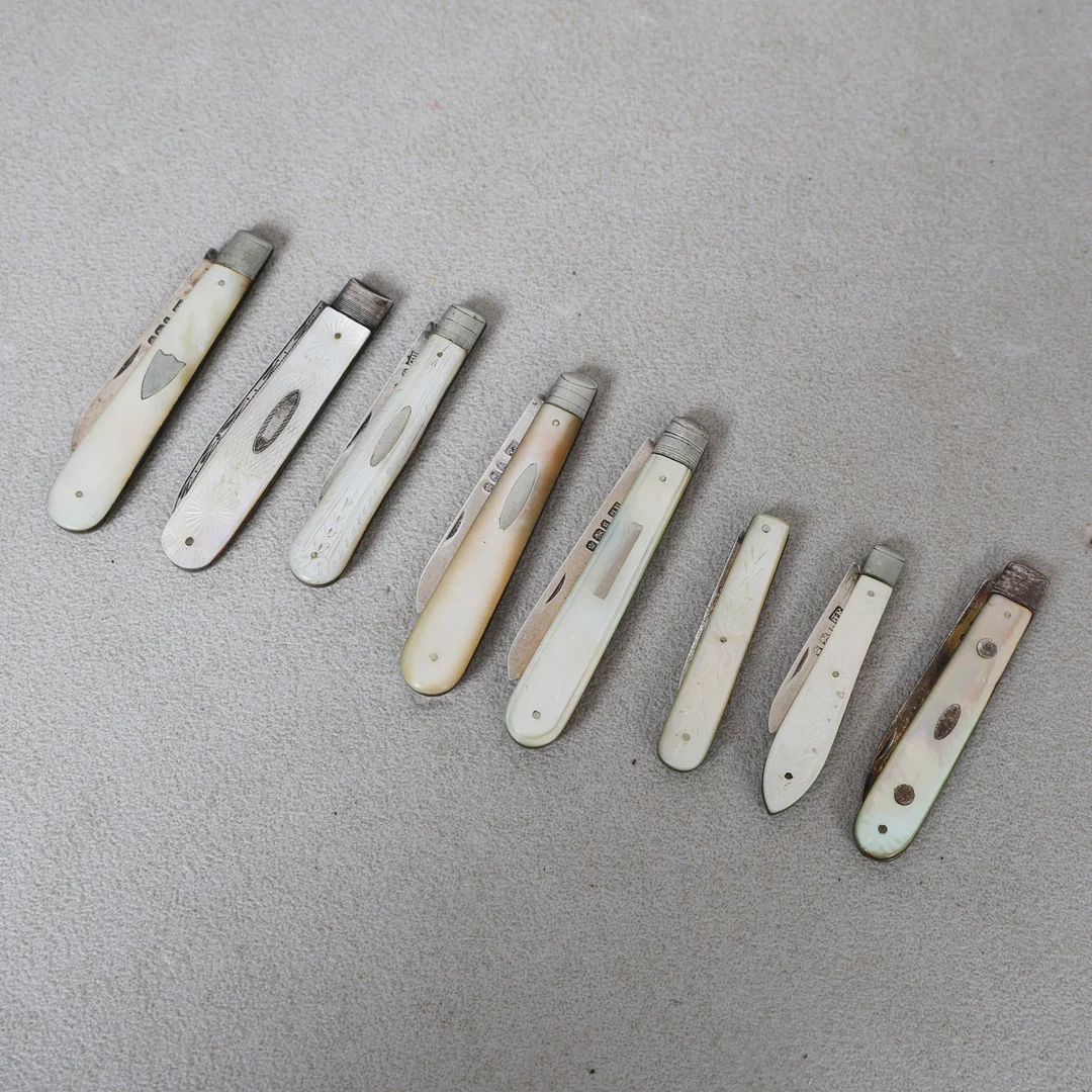 A COLLECTION OF EIGHT MOTHER OF PEARL AND SILVER BLADED FRUIT KNIVES (8). — Silver — Bishop & Miller