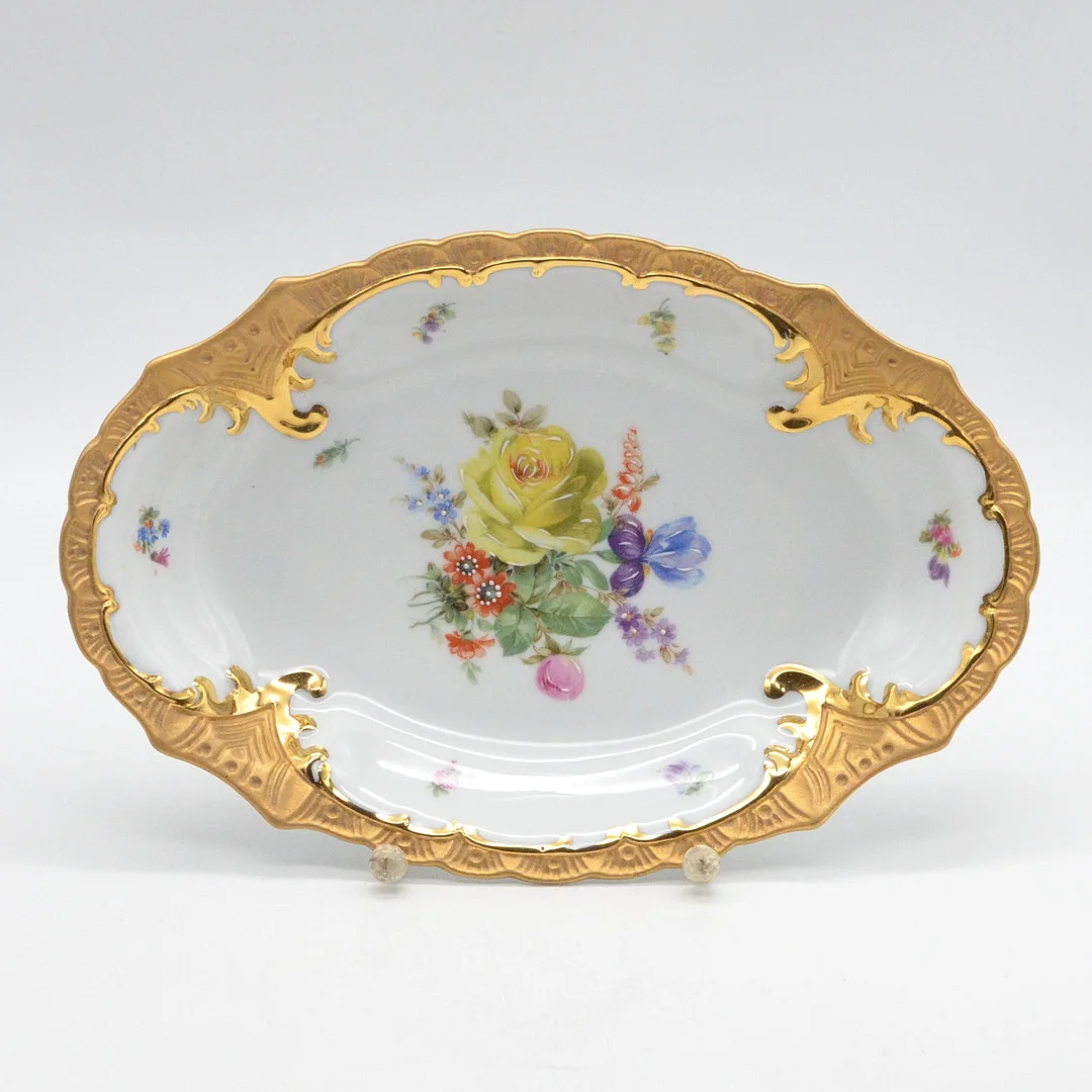 OSCAR SCHLEGELMILCH. ZIERTELLER AUS PORZELLAN, MODELL 0182, BLUMENDEKOR (MIT WEISSHÖHUNGEN) UND GOLDRAND (GLÄNZEND UND MATTIERT), FRÜHES 20. JAHRHUNDERT, ETIKETT VON LOHNSTEIN WORMS. — European — Kunst- und Auktionshaus Kleinhenz
