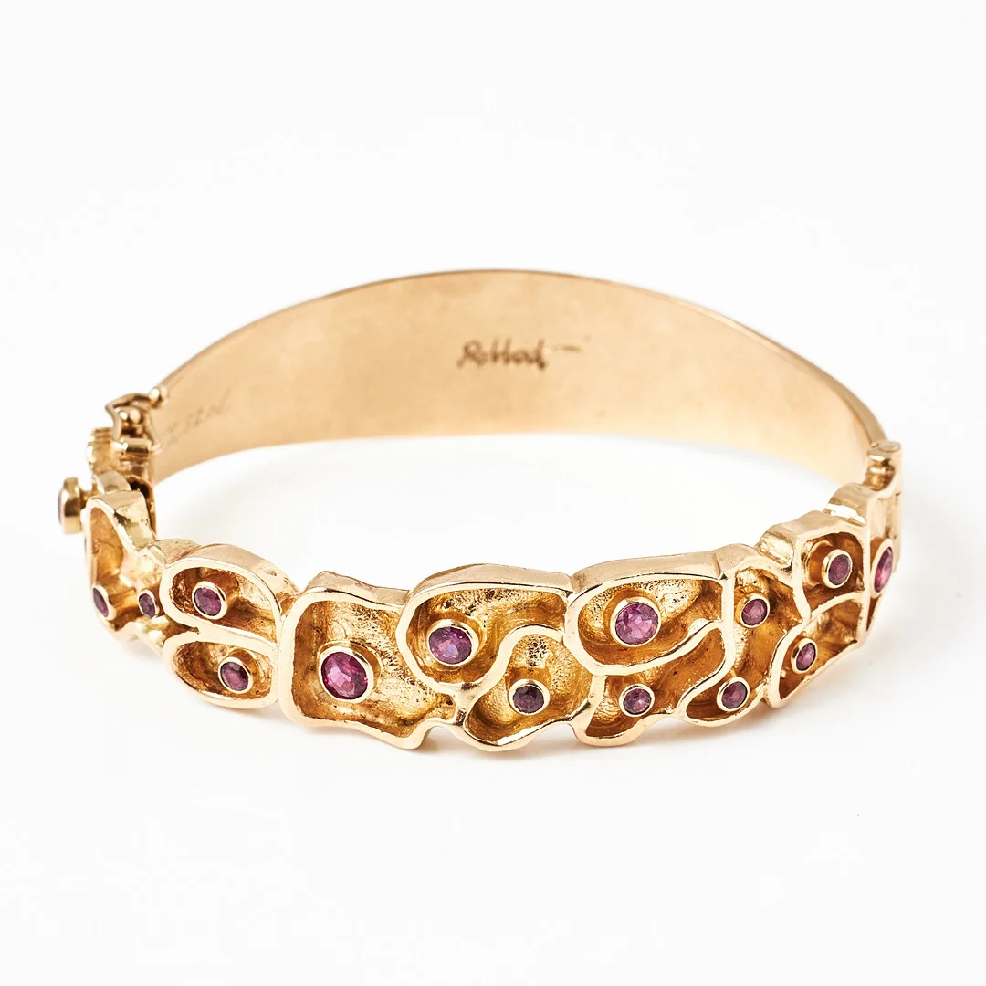 ARMRING, 18 k guld, dekor med 16 fasettslipade rubiner totalt 2,68 ct., organisk form, brutalistisk stil, Silversmedjan Trosa Kvarn, Inger Robbert, Trosa 1971, stämpelsignerad Robbert. — Bracelets — Stockholms Auktionsverk Magasin 5