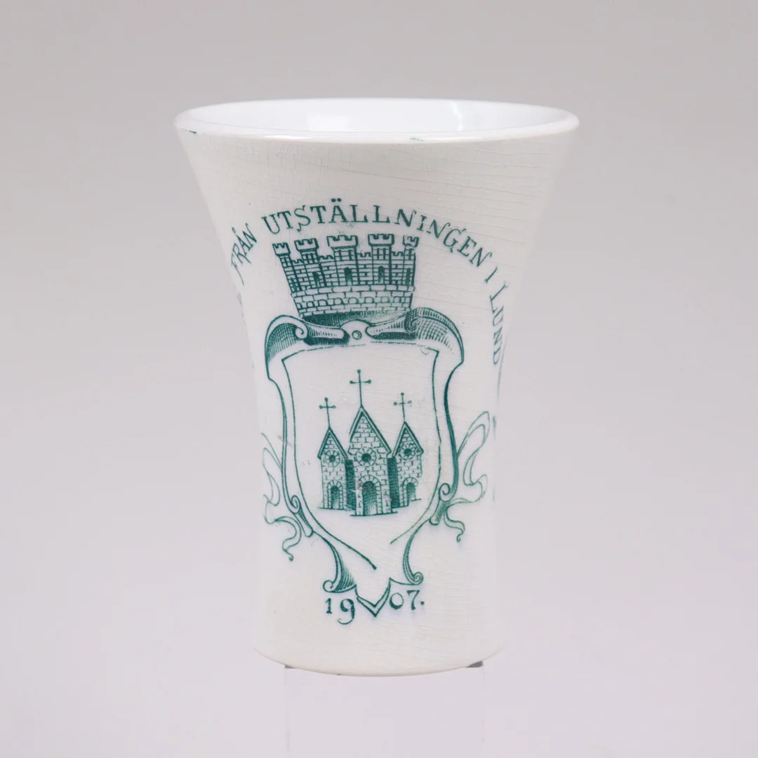 MINNES -/KAFFEBÄGARE, Minne från utställningen i Lund, 1907, Gustavsberg, flintgods. — European — Markus Auktioner
