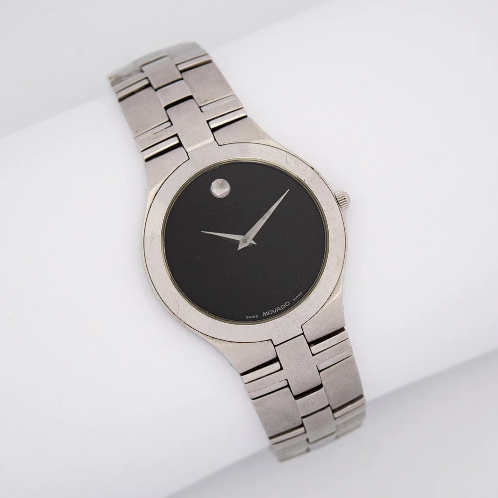 MOCADO JURO ARMBANDUHR, QUARTZWERK, EDELSTAHL MIT EINEM CHARAKTERISTISCHEN SCHWARZEN ZIFFERBLATT, KRATZFESTES SAPHIRGLAS, BIS ZU 30 METER WASSERDICHT, SILBERFARBENER STUNDENINDEX BEI 12 UHR, EDELSTAHLARMBAND. — Wristwatches — Kunst- und Auktionshaus Kleinhenz