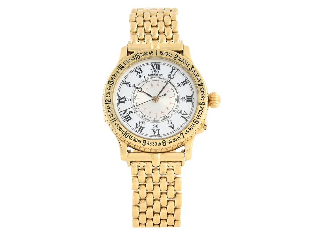 LONGINES, Charles Lindbergh, Replica av "Hour Angle Watch", Cal L989, Serie nr. 58051196, Ref nr. 989.5216, Boett nr. 24763441, herrur, 38 mm, 18K guld, automatisk, mineralglas, emaljurtavla, öppningsbar bakboett med glasad innerboett, originallänk i 18K guld, längd 210 mm, totalvikt 129,67 gram, cert (ej komplett), ca mars 1990. — Klockor/Longines — Kaplans
