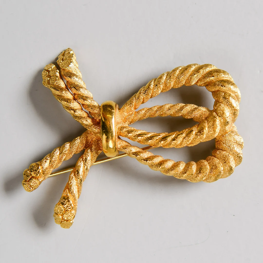 CHRISTIAN DIOR, brosch, knut, förgylld metall. — Brooches & Pendants — Formstad Auktioner