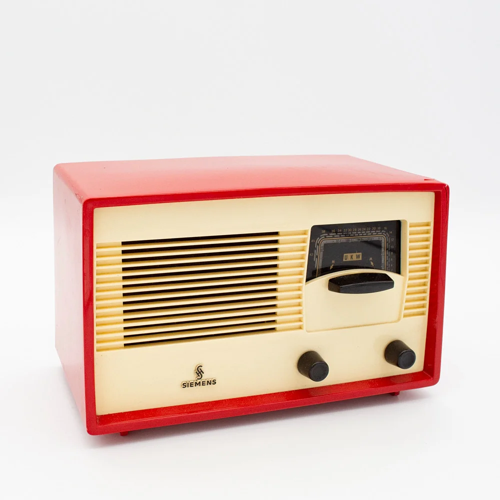 HISTORISCHES RÖHREN-TISCHRADIO VON SIEMENS, MODELL SIEMENS SUPER A 60, 1950ER JAHRE, GEHÄUSE ROTER KUNSTSTOFF MIT EINER ELFENBEINFARBENEN FRONTBLENDE, EINEM LAUTSPRECHERGITTER UND SCHWARZEN DREHKNÖPFEN. — Audio, Vinyl & Hi-Fi — Kunst- und Auktionshaus Kleinhenz