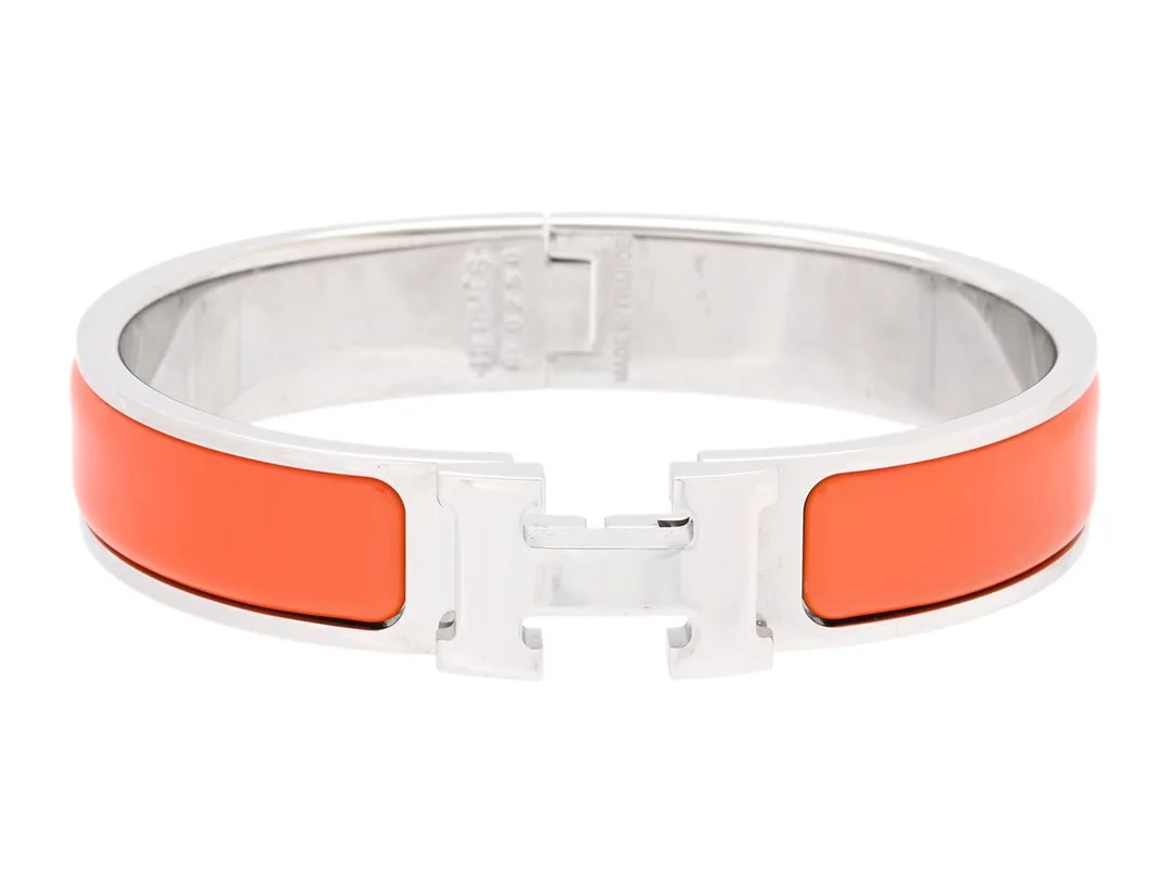 HERMÈS, ARMRING, Clic H Bracelet, orange emalj, palladiumpläterade beslag, bredd 1 cm, diameter 5,5 cm, Made in France, smyckespåse, originalask. Excellent Condition. — Smycken/Armring — Kaplans