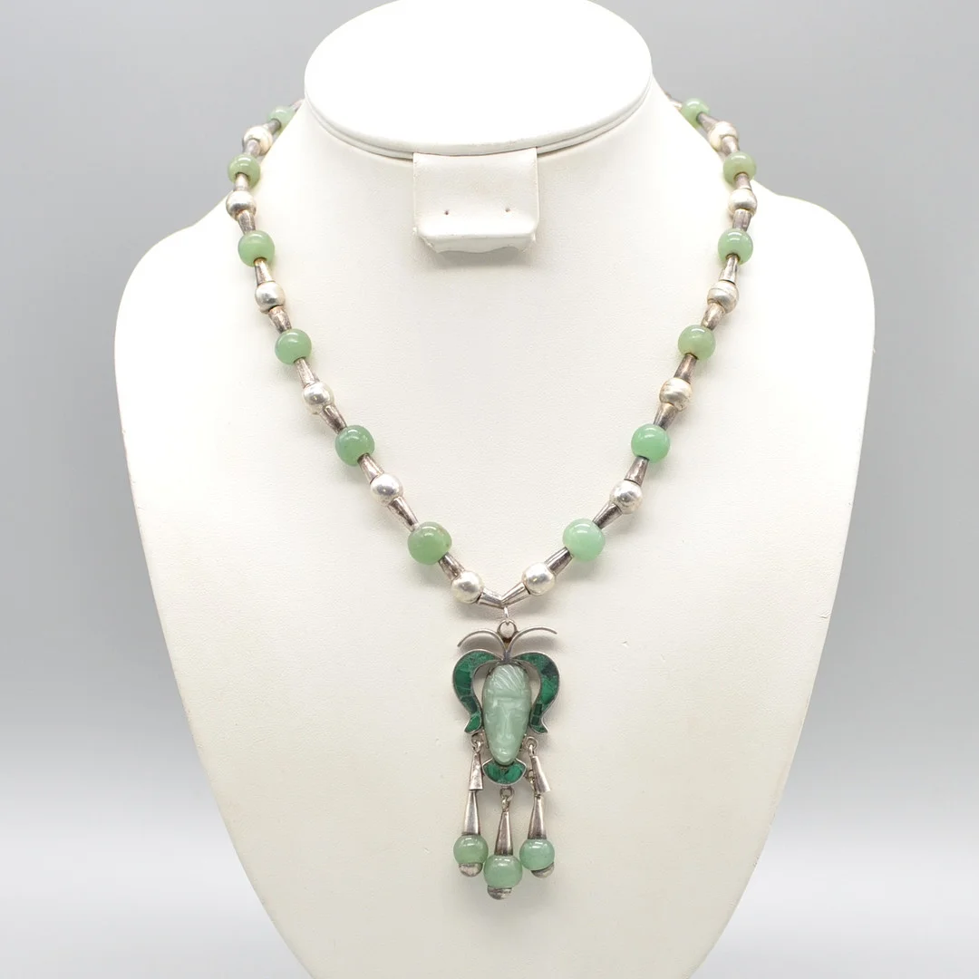 DESIGNERCOLLIER MIT JADE, MALACHIT UND STERLINGSILBER, TAXCO MEXICO TC-113, AZTEKEN-KOPF-ANHÄNGER, STECKVERSCHLUSS, ZWEIFACH GESTEMPELT, 20. JAHRHUNDERT. — Necklace — Kunst- und Auktionshaus Kleinhenz
