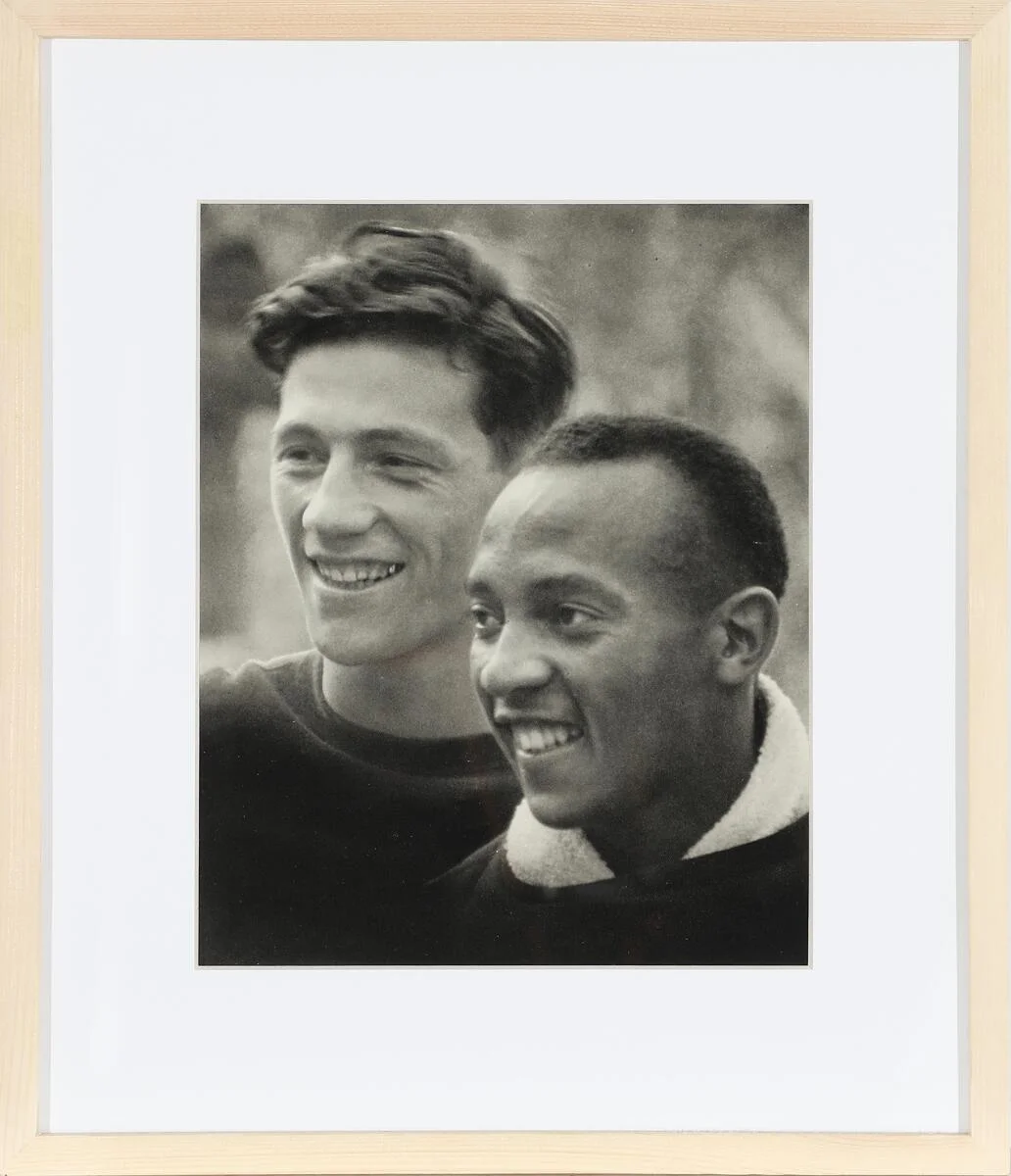 Four-time American Olympic gold medallist Jesse Owens (1913–1980) with German athlete Carl Ludwig Long (1913–1943). Black-and-white recording from 1936. The present photogravure made that same year. Pinewood frame. Visible size 23 × 19 cm. Frame size 35 × 31 cm. — Photos/Vintage photographs — Bruun Rasmussen