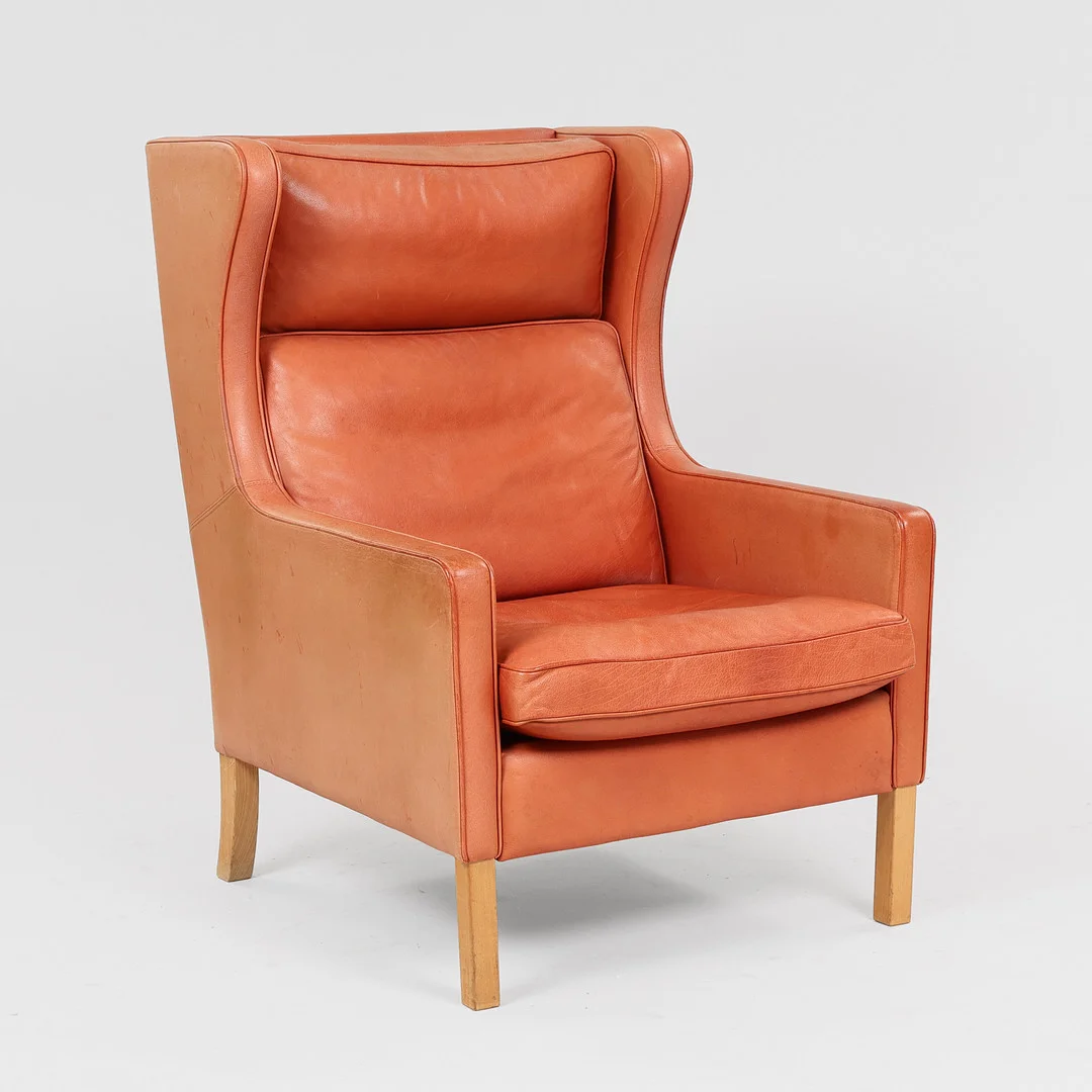 STOUBY. "Lulu", højrygget hvilestol med ben af bøg, sæde, ryg og løse hynder betrukket med brunt skind, Danmark, 1900-tallets anden halvdel. — Armchairs & Chairs — Palsgaard Kunstauktioner