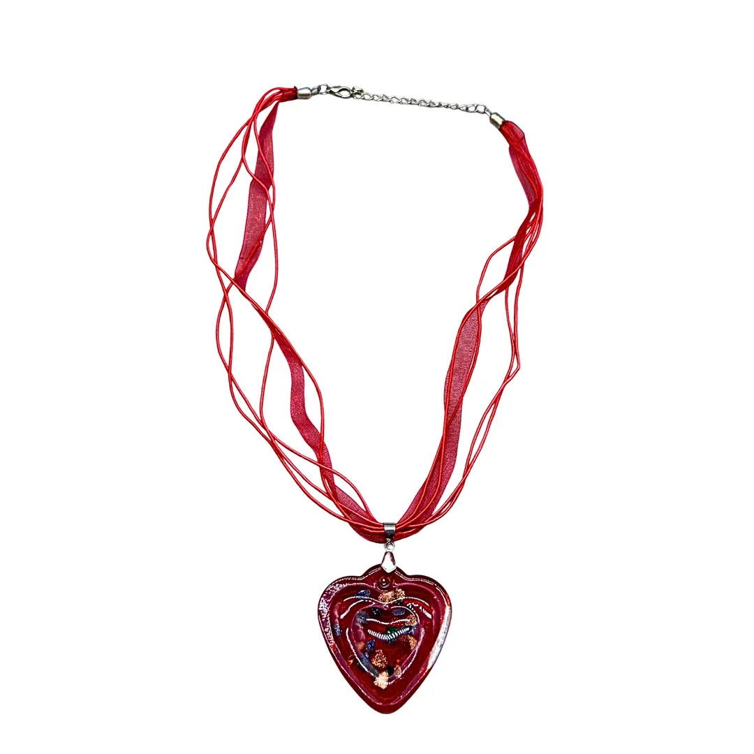 HALSKETTE AUS TEXTIL MIT EINEM HERZFÖRMIGEN ANHÄNGER AUS GLAS. — Jewellery — Auktionshaus Stuber's Hammerschlag