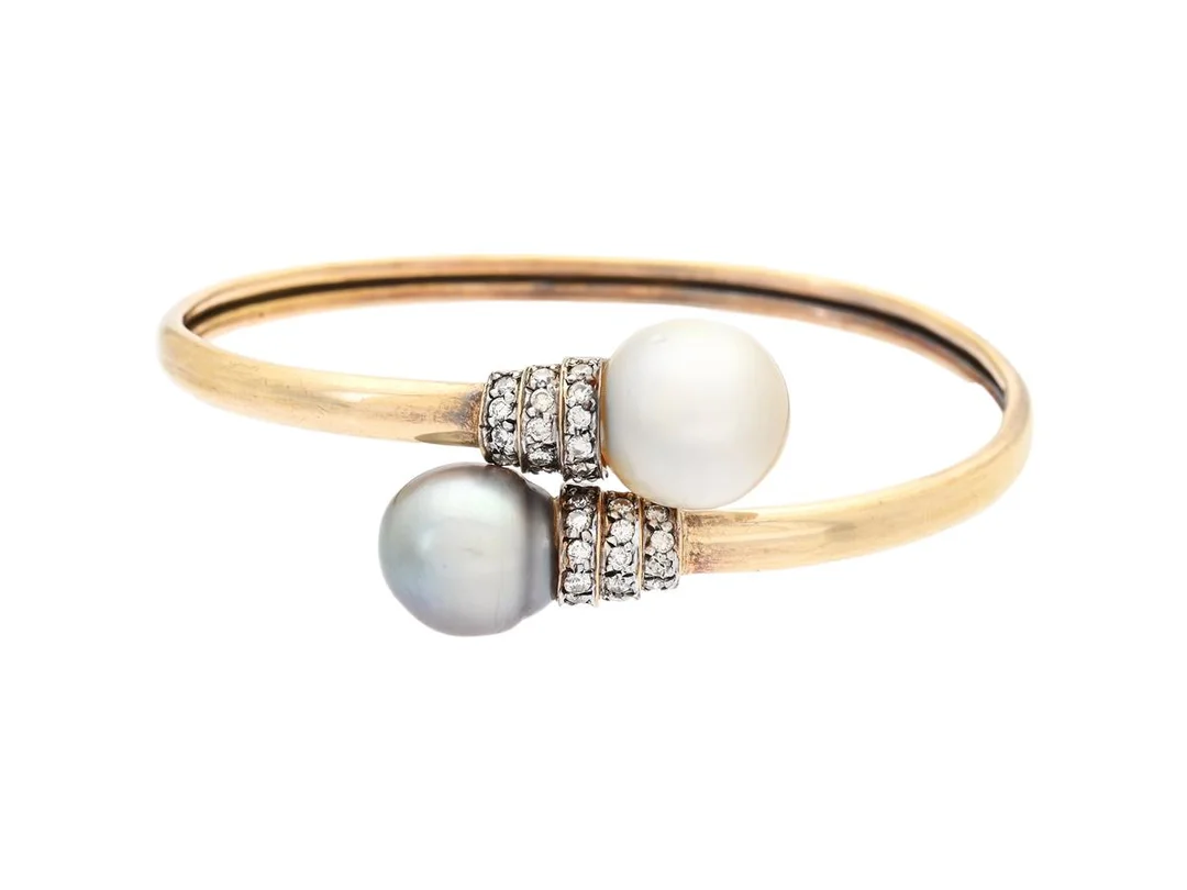 ARMRING, 14K guld, 2 odlade Tahiti och South Seapärlor, briljantslipade diamanter ca 0,45 ctv, ca Cr-LY/SI-P, 47x55 mm , vikt 14,8 g, några diamanter med nagg, svaga fattningar. — Smycken/Armring — Kaplans