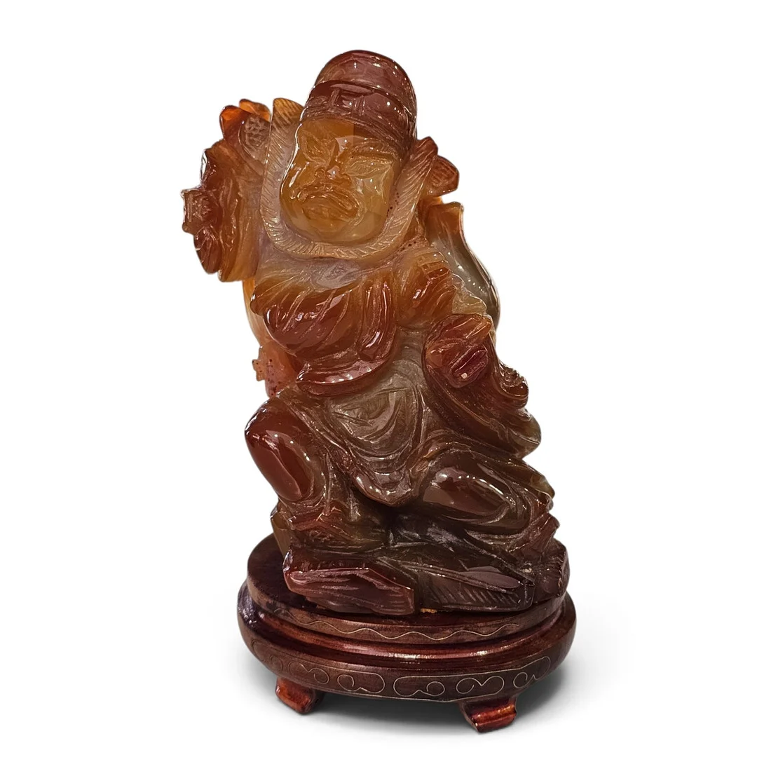 Figura de guerrero en ágata tallada con base en madera. — Other — Arce Auctions