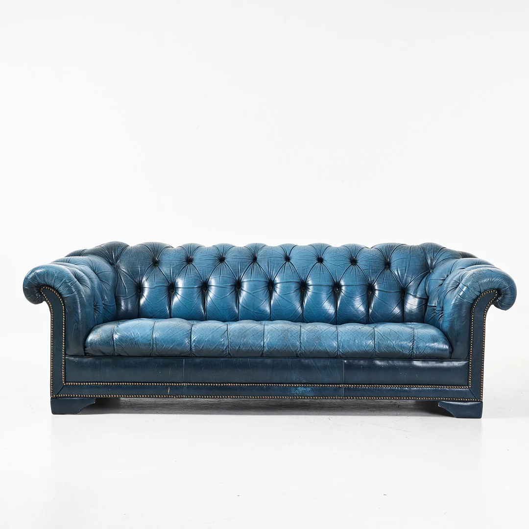 SOFFA. Chesterfield, 1900-talets andra hälft, blå skinnklädsel, pärlspikad dekor, lösa sittplymåer. — Sofas & Seatings — Stockholms Auktionsverk Magasin 5
